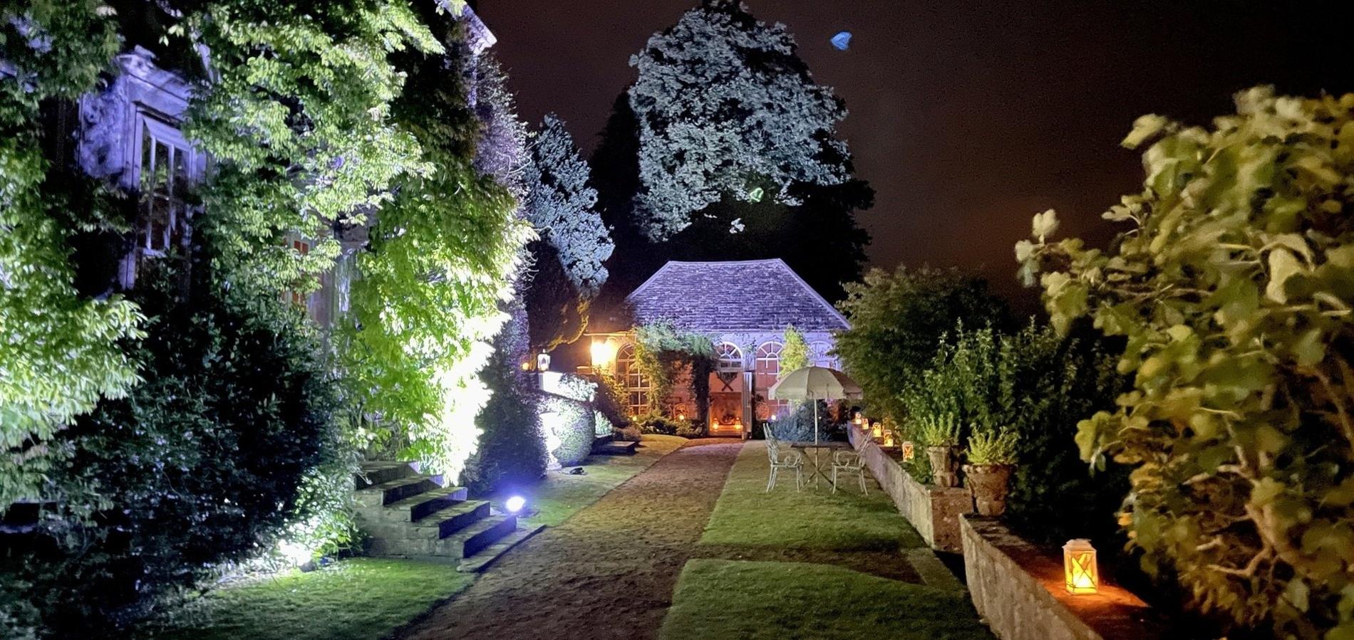 The terrace and orangery lit by lanterns at night