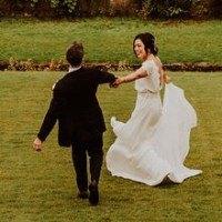 Couple running across the lawn